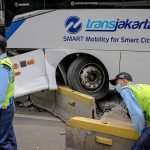 Petugas membongkar separator untuk evakuasi usai terjadinya kecelakaan bus Transjakarta yang menabrak separator di Jalan Jendral Sudirman, Jakarta Selatan, Jumat 3 Desember 2021. (Foto: BeritaSatuPhoto/Joanito De Saojoao)