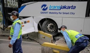 Petugas membongkar separator untuk evakuasi usai terjadinya kecelakaan bus Transjakarta yang menabrak separator di Jalan Jendral Sudirman, Jakarta Selatan, Jumat 3 Desember 2021. (Foto: BeritaSatuPhoto/Joanito De Saojoao)